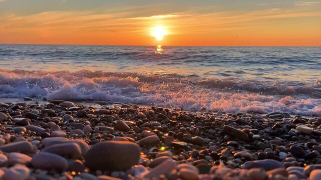 Orange sunset in Tuapse, sea waves with foam run to the shore. The Black Sea coast at sunset in the clouds. Pebble beach in the village of Agoy. The stormy sea in the evening. 4К