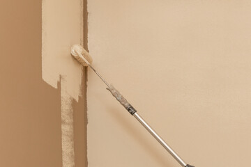 Light brown wall being painted ivory