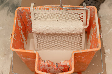 Paint roller and grate in orange bucket