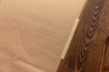 Brown paper taped to wooden floor