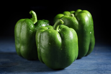 Green bell peppers on blue wooden table