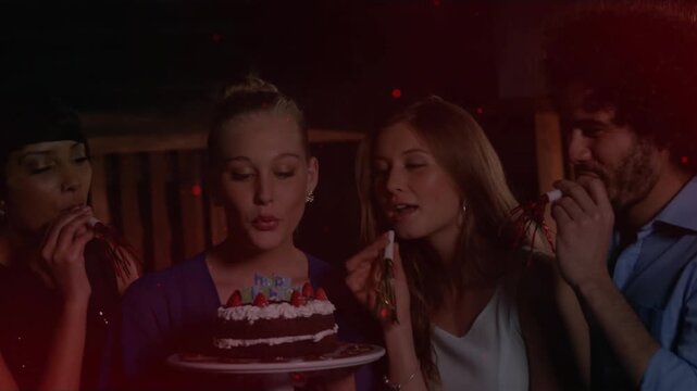 Cake-holder in purple inhaling blowing candles for birthday on deck guests blowing horns red flares