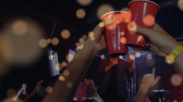 Lead singer performing, camera moving to concert crowd raising red cups toasting, bokeh over cups