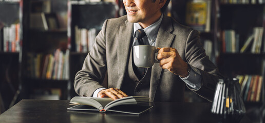 Library, Asian male businessman drinking coffee in his study (reading, literature, culture, retro, antique)
