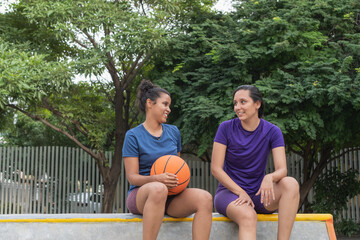 Women basketball players having friendly conversation outdoors