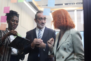 Diverse Team Working Together in Modern Co-Working Space. Casual meeting of senior diverse business team analyzing financial data. Multiethnic business people working in the office. senior man. 