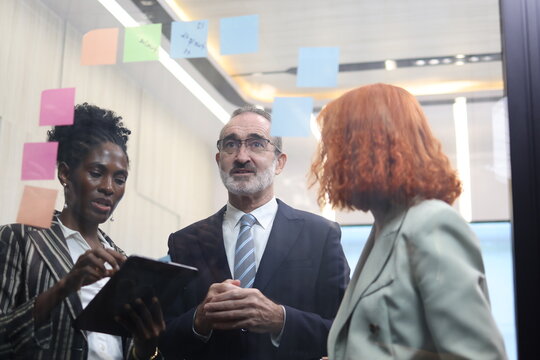 Diverse Team Working Together in Modern Co-Working Space. Casual meeting of senior diverse business team analyzing financial data. Multiethnic business people working in the office. senior man. 