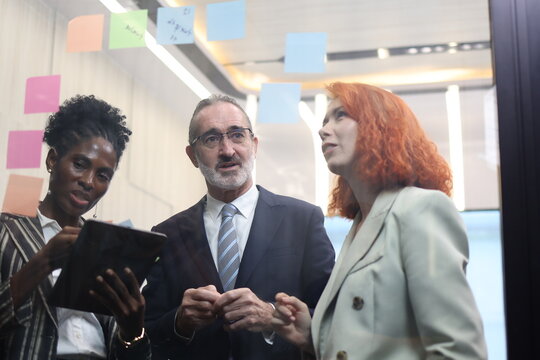 Diverse Team Working Together in Modern Co-Working Space. Casual meeting of senior diverse business team analyzing financial data. Multiethnic business people working in the office. senior man. 