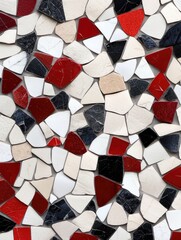 Close-up of a mosaic tile pattern featuring various shapes and colors including red, white, black, and beige.
