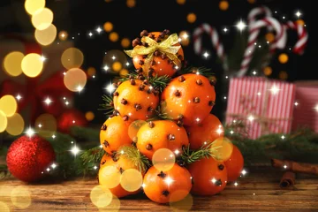 Fotobehang Beren Christmas tree made of tangerines with cloves on table. Bokeh lights  © New Africa