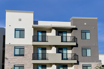 A modern multifamily apartment building with balconies, clean exterior finishes, and uniform windows, representing contemporary residential development and urban housing design