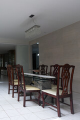 elegant dining room interior design, marble stone table and dark wooden chairs, luxury residential architecture, classic style dining area with modern crystal chandelier, white ceramic tile floor 