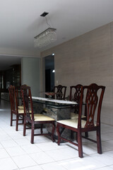 elegant dining room interior design, marble stone table and dark wooden chairs, luxury residential architecture, classic style dining area with modern crystal chandelier, white ceramic tile floor 