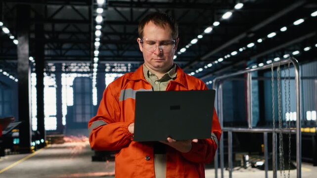 Industrial worker wearing safety glasses adjusts machinery in a warehouse, demonstrating production accuracy, engineering responsibility and efficient assembly in manufacturing process. Camera B.