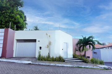 brazilian house facade, simple residential architecture, closed gate and electric fence, suburban street home