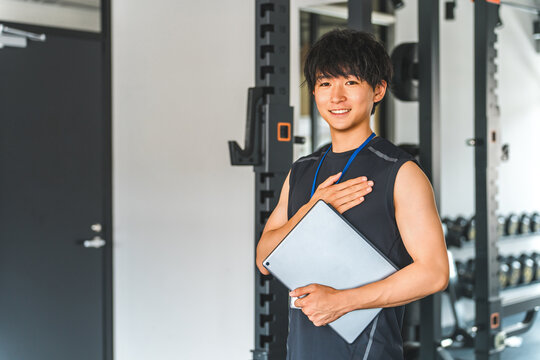 Male gym trainer, personal trainer, and instructor with tablet
