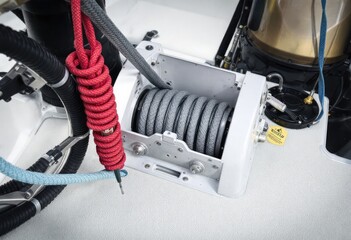 Close-up of a marine winch, gray spools, red rope