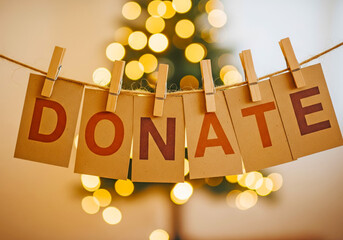 Warm holiday donate message on hanging kraft cards with festive bokeh lights for charity campaign background and seasonal awareness graphics