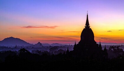 A silhouette of a pagoda against a vibrant sunset in Bagan, Myanmar. The image captures the beauty of the landscape with a colorful sky and the ancient architec