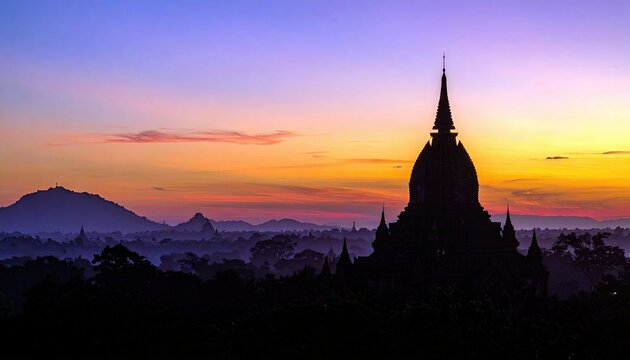 A silhouette of a pagoda against a vibrant sunset in Bagan, Myanmar. The image captures the beauty of the landscape with a colorful sky and the ancient architec