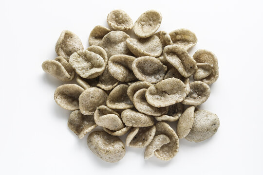 A pile of kerupuk jengkol (jengkol crackers) displayed against a clean white background.