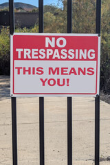 No Trespassing sign posted on wrought iron fence
