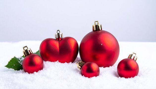 Red christmas ornaments, heart and ball on snow with white background