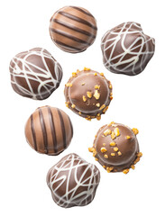 scattered group of seven round, gourmet chocolate truffles with diverse decorative toppings including white drizzle, milk stripes, and crushed nuts.