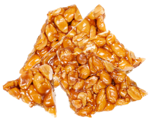 close-up photograph of several jagged pieces of traditional crunchy peanut brittle or georgian gozinaki, featuring whole nuts and caramelized honey syrup.