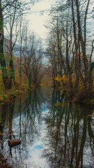 Scenic lake view in Herzegovina with cabins, abstract composition emphasizing water reflections and mountain silhouettes
