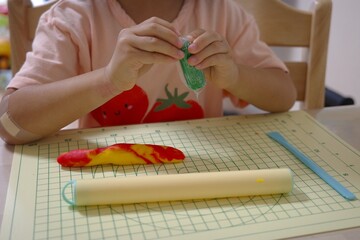 Child's Hands Playing with Clay or Playdough on a Mat (Creative Arts and Education)
