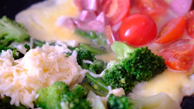 Stir-fried mixed vegetables and a fried egg on pan, healthy meal with vitamins and protein. Kind of Italian omelette with vegetables. Frittata