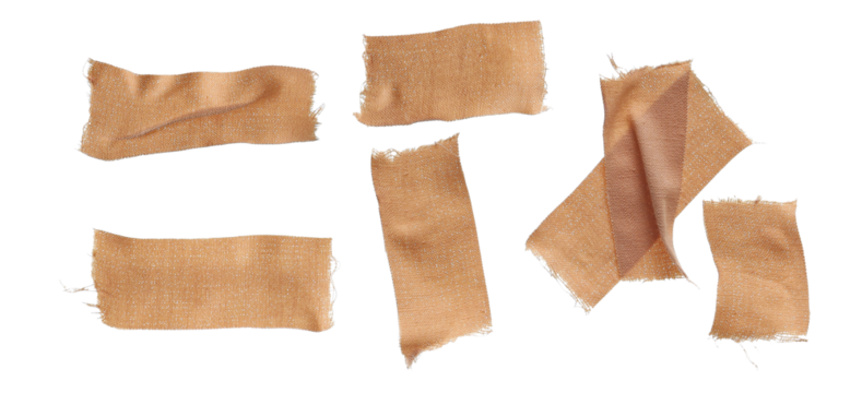 photograph of seven pieces of torn, textured, woven cloth medical plasters and bandages with ripped edges, loosely scattered on a dark transparent background.