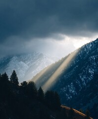 Sunlight streaming dramatically through clouds on mountain landscape nature photography outdoor scenic view