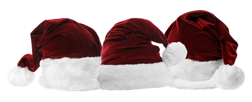 lineup of three classic red velvet santa claus hats featuring white plush trim, isolated against a pure black backdrop. - Powered by Adobe