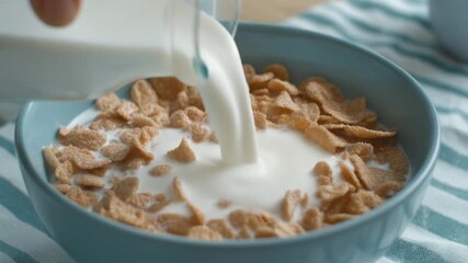 slow motion of pouring milk into a bowl filled cereal during breakfast routine - Powered by Adobe
