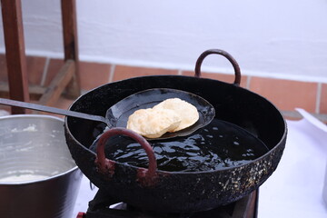 poori, puri deep fried in hot oil pot