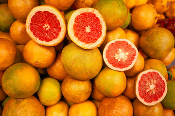 Fresh grapefruits and pink halves in close-up