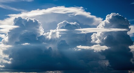 Majestic cumulus clouds rise high in a vibrant blue sky, creating a powerful and dramatic weather spectacle with fluffy white and grey formations