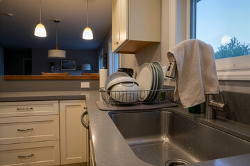 Modern kitchen sink with clean dishes and natural light