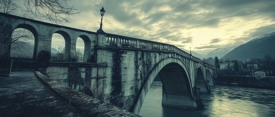Aged stone bridge spanning a river, dramatic sky
