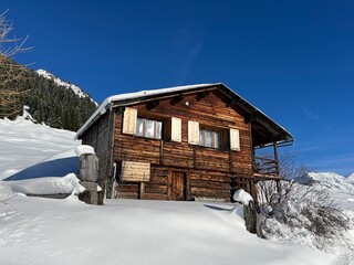 Old traditional swiss rural architecture and alpine livestock farms in the winter ambience of the alpine Swiss village St. Ant&ouml;nien - Canton of Grisons, Switzerland (Kanton Graub&uuml;nden, Schweiz)