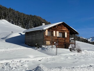 Old traditional swiss rural architecture and alpine livestock farms in the winter ambience of the alpine Swiss village St. Ant&ouml;nien - Canton of Grisons, Switzerland (Kanton Graub&uuml;nden, Schweiz)
