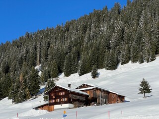 Old traditional swiss rural architecture and alpine livestock farms in the winter ambience of the alpine Swiss village St. Ant&ouml;nien - Canton of Grisons, Switzerland (Kanton Graub&uuml;nden, Schweiz)