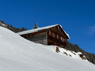 Old traditional swiss rural architecture and alpine livestock farms in the winter ambience of the alpine Swiss village St. Ant&ouml;nien - Canton of Grisons, Switzerland (Kanton Graub&uuml;nden, Schweiz)