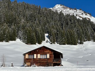 Old traditional swiss rural architecture and alpine livestock farms in the winter ambience of the alpine Swiss village St. Ant&ouml;nien - Canton of Grisons, Switzerland (Kanton Graub&uuml;nden, Schweiz)