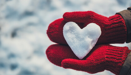 Red wool mittens gently holding heart shaped snow sculpture, symbolizing warmth and love in winter outdoor setting, cozy and minimal with soft snowy background