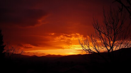 Fiery sunset over dark silhouette mountains