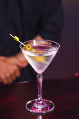 Elegant cocktail, martini garnished with olives, in a stylish bar setting 