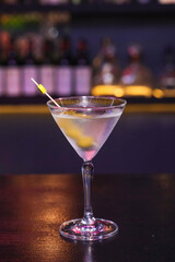 A delicious cocktail garnished with a lemon twist, perfectly chilled in a classic martini glass. The ambiance is one of relaxation, perfect for a night out.